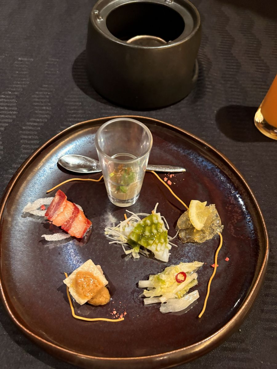 コース「朱雀」の前菜「六種冷菜盛り合わせ」。オレンジジュースが添えられている(筆者撮影)